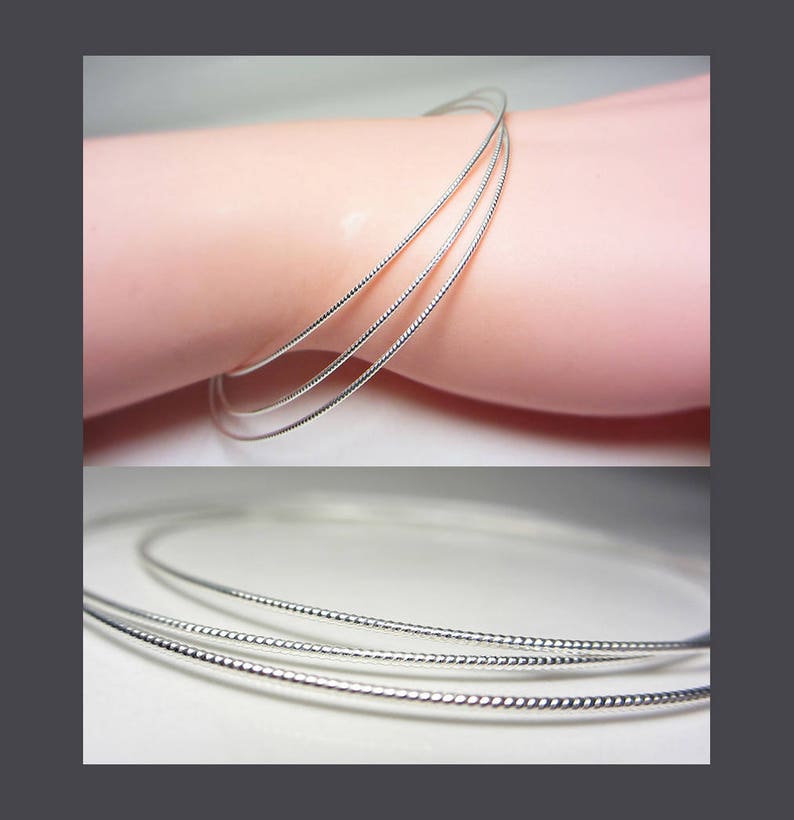 May include: A set of three silver-colored bangles with a textured, beaded design. The bracelets are shown on a light pink surface, with a close-up view of the bracelets below.