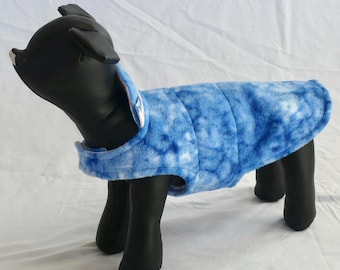 May include: A blue and white tie-dye dog coat. The coat is quilted and has a collar. The dog coat is designed to fit a small dog. The dog coat is made of a soft, plush material.
