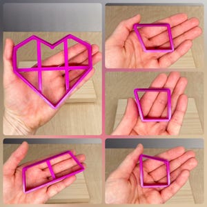May include: Four pink plastic cookie cutters in the shapes of a heart, a diamond, a rectangle, and a square. The cutters have a grid pattern inside.
