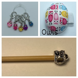 May include: A set of owl-themed knitting accessories, including stitch markers, a needle holder, and a pincushion. The pincushion is round and features a white background with colorful owls printed on it. The text "Owls" is printed below the pincushion.