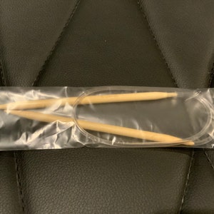 以下が含まれることがあります： 透明なプラスチック袋に入った木製の編み針2本。針の長さは約25cmで、天然木で作られています。