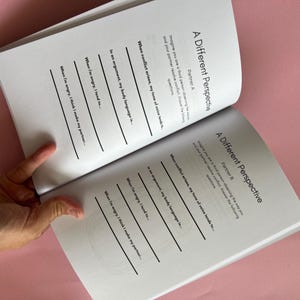 May include: A black and white workbook with the title "A Different Perspective" on the cover. The workbook is open to a page with questions about conflict resolution and communication.