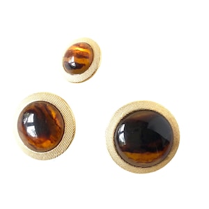 May include: Set of three gold-toned round buttons with brown and black marbled centres.