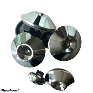 May include: Five silver-toned metal buttons with a raised center and a smooth, shiny finish. The buttons are arranged in a cluster, with some overlapping.