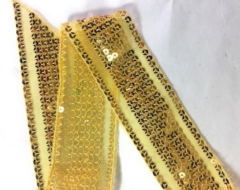 May include: Yellow sequined trim with a mesh backing. The trim has a repeating pattern of gold sequins.