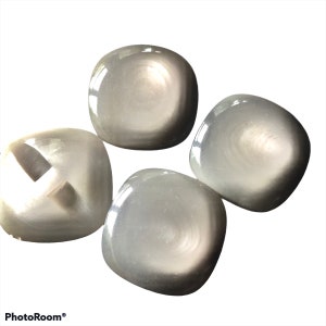 May include: Four smooth, round, grey stones with a white iridescent sheen. The stones are arranged in a cluster.