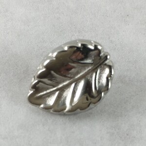 May include: A silver leaf-shaped cabinet knob with a detailed design.