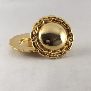 Puede incluir: Un par de pendientes de botón de metal dorado con un diseño circular texturizado.