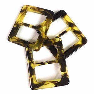 Puede incluir: Tres cierres de hebilla de pl&aacute;stico de imitaci&oacute;n de caparaz&oacute;n de tortuga. Las hebillas son de forma cuadrada con una doble abertura rectangular. Las hebillas son de color marr&oacute;n y amarillo moteado.
