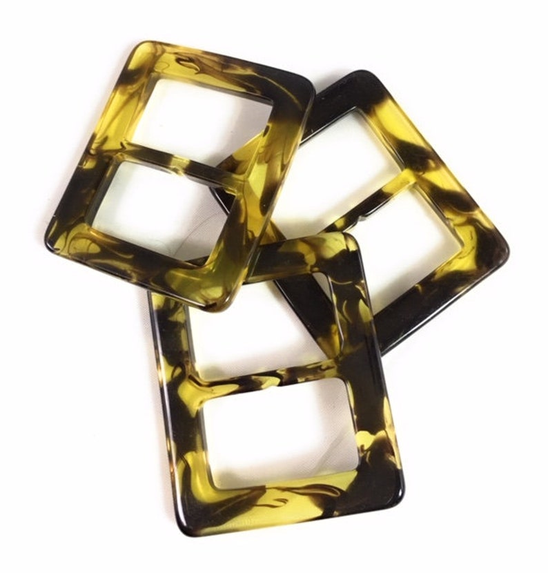 Puede incluir: Tres cierres de hebilla de pl&aacute;stico de imitaci&oacute;n de caparaz&oacute;n de tortuga. Las hebillas son de forma cuadrada con una doble abertura rectangular. Las hebillas son de color marr&oacute;n y amarillo moteado.