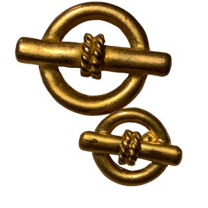 May include: Two gold-toned metal toggle clasps with a rope design. The larger clasp has a diameter of approximately 2 inches, while the smaller clasp has a diameter of approximately 1 inch.