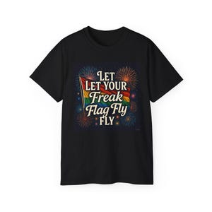 May include: Black t-shirt featuring a rainbow flag design with the text "Let Your Freak Flag Fly" in a stylized font. The design includes fireworks in the background, creating a celebratory feel.