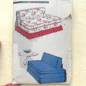 May include: An Advance Decorator Pattern envelope featuring illustrations of two sofa styles. One sofa has a floral print with a red ruffled base, and the other is solid blue. The text reads Advance Decorator Pattern and THE EASY PRINTED PATTERN.