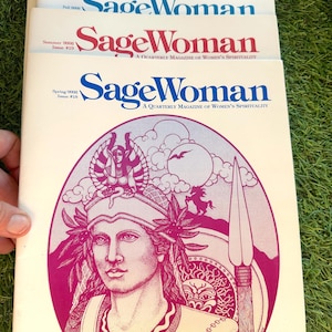 Könnte beinhalten: Ein Stapel "SageWoman"-Magazine. Die Cover zeigen den Magazintitel in verschiedenen Farben, wobei das untere Magazin eine detaillierte Illustration einer Frau mit einem Speer zeigt. Der Text "A Quarterly Magazine of Women's Spirituality" ist ebenfalls sichtbar.