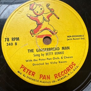 May include: A yellow vinyl record with a gingerbread man illustration. The record is labeled "The Gingerbread Man" and features the text "Sung by Betty Bonnie" and "Peter Pan Records".