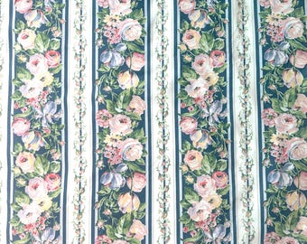 May include: Floral fabric with vertical stripes. The design features alternating stripes of white, navy blue, and floral arrangements. The floral arrangements include pink, yellow, and purple flowers with green leaves.