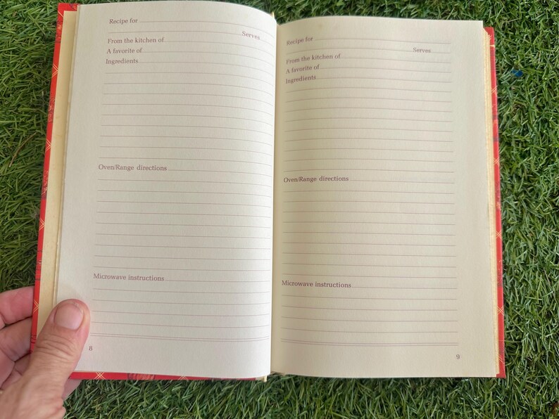 May include: Open cookbook with lined pages for recipes. The red cover has a plaid pattern. Text includes "Recipe for," "From the kitchen of," and "Oven/Range directions." The book is open to pages 8 and 9.