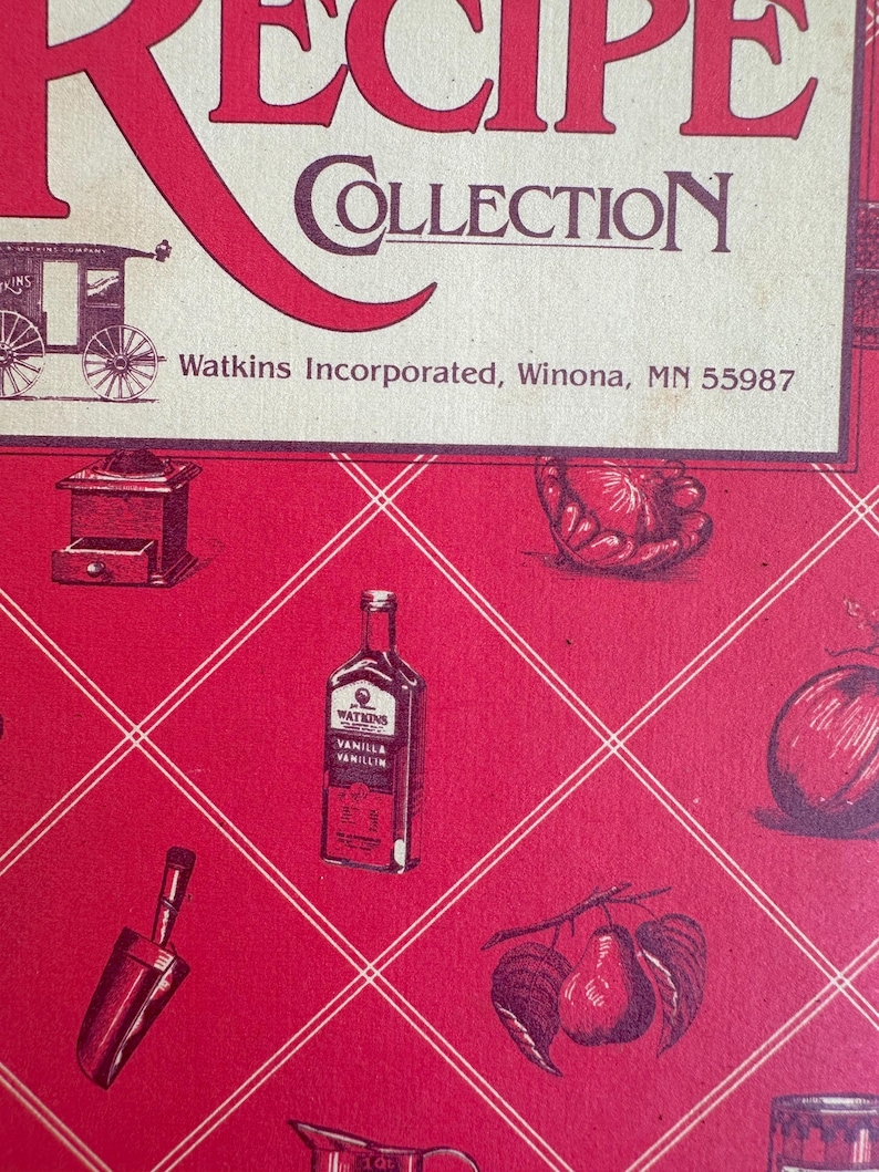 May include: A red and cream-colored recipe collection cover with the words "Recipe Collection" in large red letters. The cover features illustrations of kitchen items and a bottle of vanilla extract. The text "Watkins Incorporated, Winona, MN 55987" is also visible.
