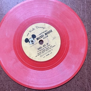 May include: Red vinyl record with a label featuring Mickey Mouse and the text "From Walt Disney's Official Mickey Mouse Club" and "Sho-Jo-Ji (A Japanese Play Song)".
