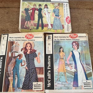 May include: Three vintage McCall's sewing pattern envelopes. The envelopes feature illustrations of women in various dresses and outfits. The patterns are from the era of Post Cereals and are marked with the text "pounds-thinner pattern".