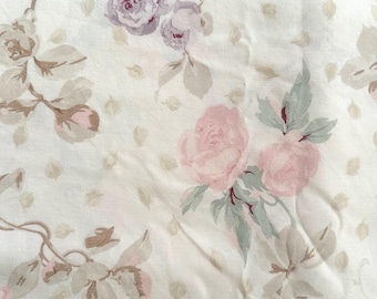 Sábana plana de percal vintage suave con estampado floral pálido y descolorido con flores rosas y moradas.