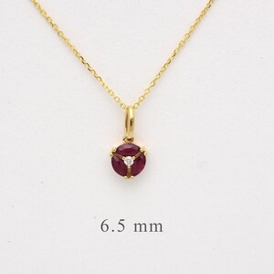 May include: A gold necklace with a pendant featuring a ruby and diamond set in a gold setting. The pendant is 6.5 mm in diameter.