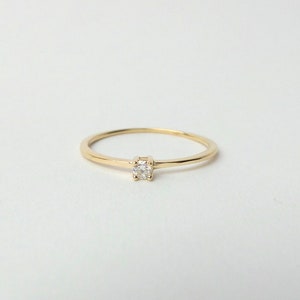 Può includere: Un anello semplice in oro con un piccolo diamante al centro.