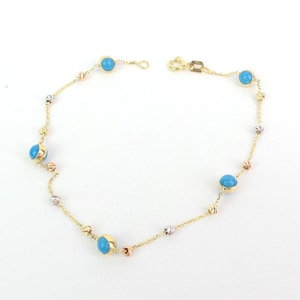 Könnte beinhalten: Ein goldenes Kettenarmband mit blauen Edelstein-Akzenten. Die Kette besteht aus drei verschiedenen Goldfarben: Gelb, Weiß und Rotgold.