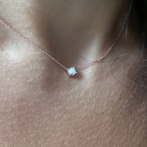 Puede incluir: Un delicado collar de cadena de oro rosa con un peque&ntilde;o colgante de &oacute;palo blanco.