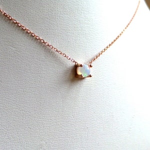 Puede incluir: Un delicado collar de cadena de oro rosa con un peque&ntilde;o colgante de &oacute;palo de forma ovalada.
