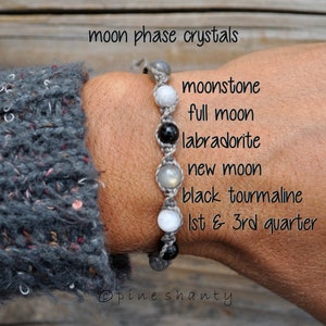 May include: A grey macrame bracelet with moonstone, labradorite, and black tourmaline beads. The text on the image reads "moon phase crystals", along with other related text.
