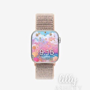 Könnte beinhalten: Eine Smartwatch mit einem beigefarbenen Stoffarmband. Das Zifferblatt zeigt ein farbenfrohes Design mit rosa, blauen und goldenen Akzenten, Muscheln sowie die Uhrzeit 9:15 und das Datum 16. Sept. Der Markenname "lilly ASHLEY" steht unten rechts.