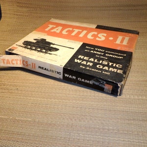 May include: A vintage box game called "Tactics II: Realistic War Game" by Avalon Hill. The box features a black and white illustration of a tank and the game title in bold, orange letters.