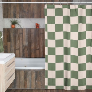 May include: A green and white checkered shower curtain hangs in a bathroom with a wooden wall and a white bathtub.