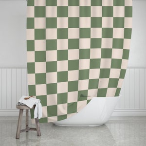 May include: A green and cream checkered shower curtain hangs in a bathroom. The curtain is made of a soft, water-resistant fabric and is perfect for adding a touch of style to any bathroom.