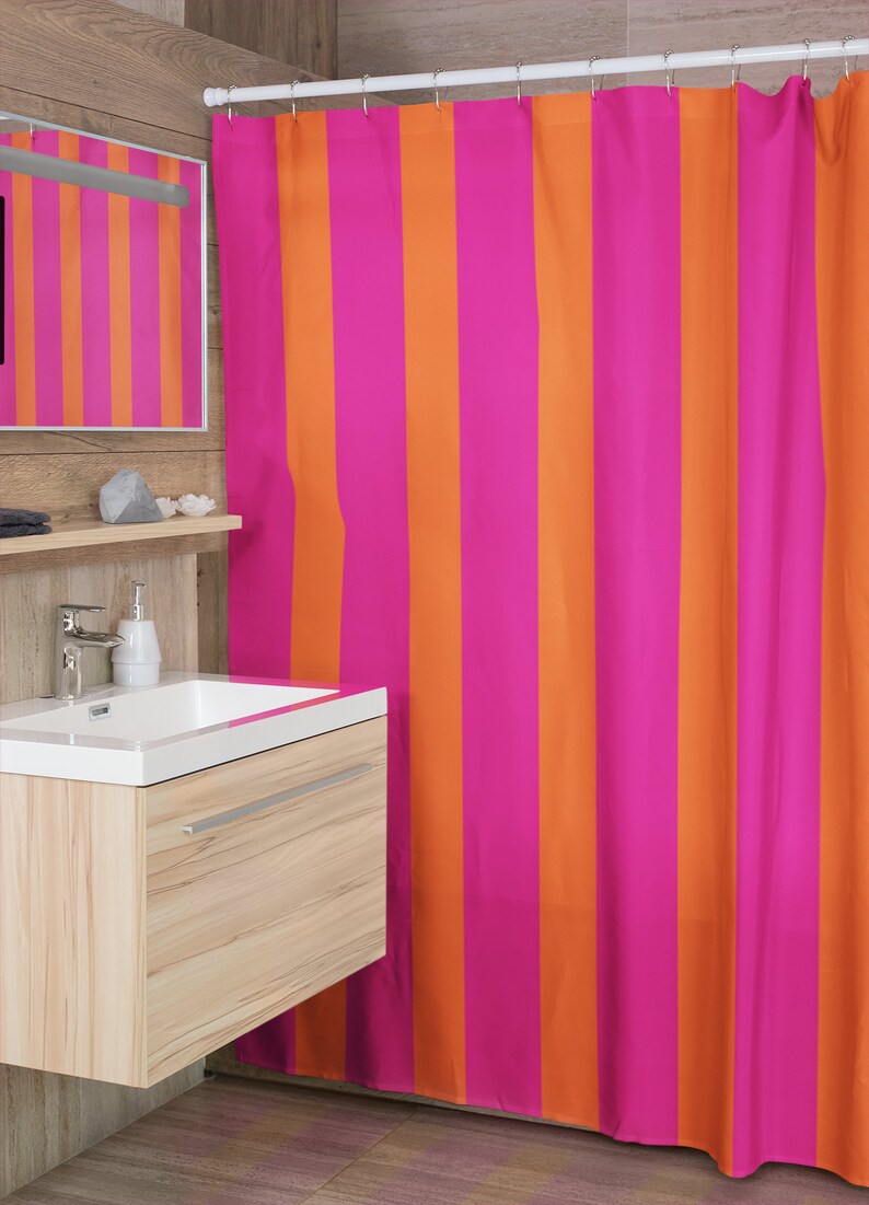 May include: A pink and orange striped shower curtain. The curtain is made of a soft, water-resistant fabric and is perfect for adding a pop of colour to any bathroom.