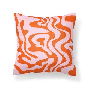 May include: Orange and pink patterned throw pillow with a wavy abstract design.