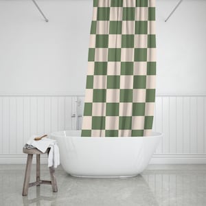 May include: A white bathtub with a green and white checkered shower curtain in a bathroom setting.