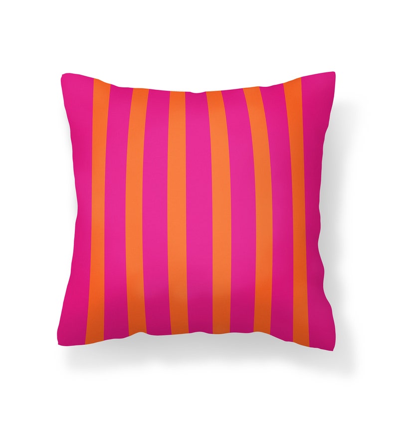 May include: A pink and orange striped cushion. The cushion is rectangular and has a soft, plush texture.