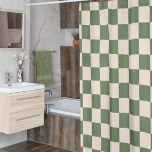 May include: A green and white checkered shower curtain hangs in a bathroom with a white bathtub and wood-look tile.
