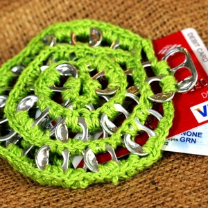 May include: A green crocheted coin purse with a VISA debit card inside. The purse is made from pull tabs from aluminium cans.