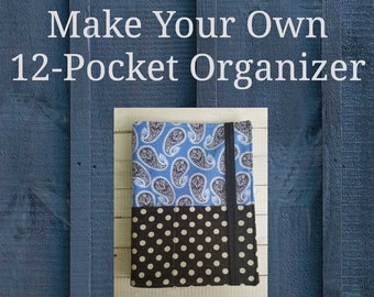Op de afbeelding: Een blauwe en zwarte stoffen organizer met 12 vakken. De organizer is gesloten en heeft een zwarte band. De tekst "Make Your Own 12-Pocket Organizer" staat bovenaan de afbeelding. De tekst "Includes Word Document & PDF Files" staat onderaan de afbeelding.