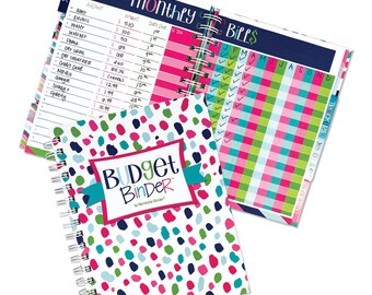 May include: A colorful budget binder with a polka dot pattern in pink, blue, green, and white. The binder has a white cover with the text "Budget Binder" in teal and black. The binder has a spiral binding and is open to a page with a monthly bill tracker.