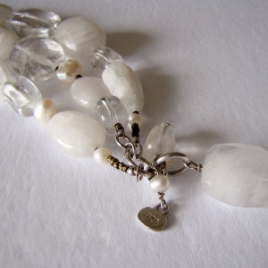 May include: A white crystal bead necklace with a silver clasp and a tag that reads '.925'.