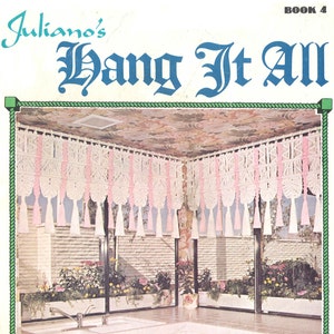 May include: A pink and white macrame curtain with tassels hangs in a kitchen with white cabinets and a double sink. The title "Juliano's Hang It All Book 4 Sweet and Sassy" is printed on the page.