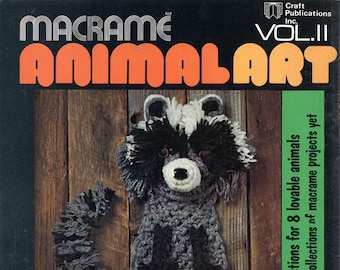 May include: A book cover with the title "Macrame Animal Art" in orange and black lettering. The cover features a black and white macrame raccoon, a black and white macrame panda, a black and white macrame turkey, and a black and white macrame snail.