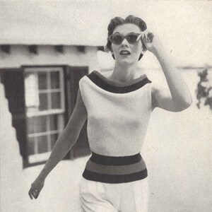 Puede incluir: Una mujer con un top blanco sin mangas con una banda de cintura a rayas negras y marrones y pantalones cortos blancos. Lleva gafas de sol y tiene el pelo recogido hacia atrás.