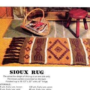 May include: Sioux rug with a geometric pattern in brown, gold, and white. The rug has a diamond design in the center and vertical stripes. It measures 18.5" x 33" with a 6" fringe. The text "SIOUX RUG" is at the bottom.