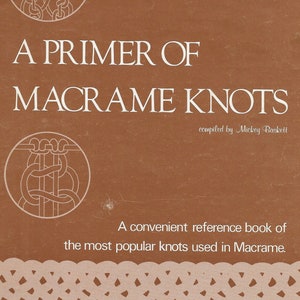 May include: A brown book cover with the title "A Primer of Macrame Knots" and the text "compiled by Mickey Baskett". The cover also features two illustrations of macrame knots.