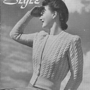 May include: A black and white photo of a woman wearing a white cable knit cardigan. The cardigan has a V-neck and buttons down the front. The woman is looking off to the side and has her hand up to her face. The text "Style" is at the top of the image and "A Patons & Baldwins Publication - 1/-" is at the bottom of the image.